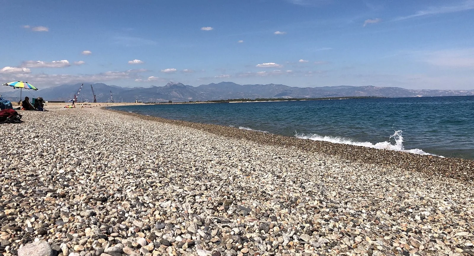 Spiaggia di ciottoli di Schiavonea con il mare Ionio e le montagne sullo sfondo
