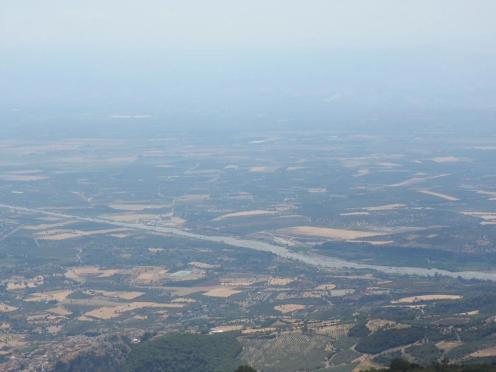 Veduta dall'alto della Piana di Sibari con campi, uliveti e agrumeti attraversati da un fiume